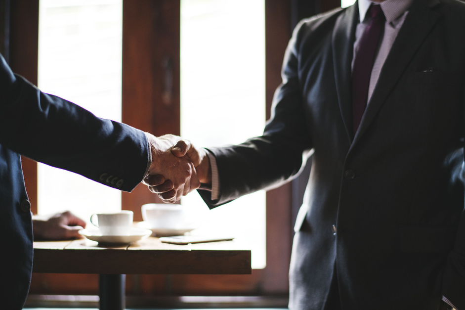 Two business people in a suit and tie shaking hands. Convertibill Blog